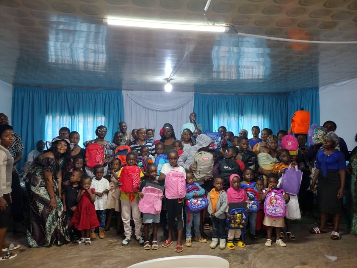 COHEC volunteers and children with new backpacks at a past Back to School distribution